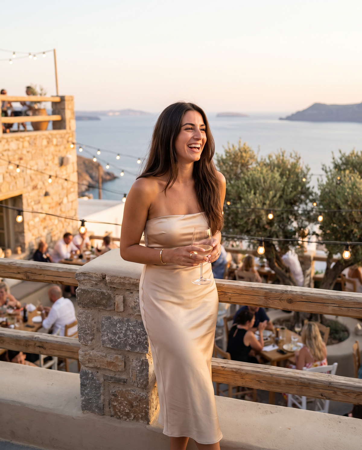 Woman laughing in a satin strapless dress at a sunset rooftop dinner | Under a strapless dress